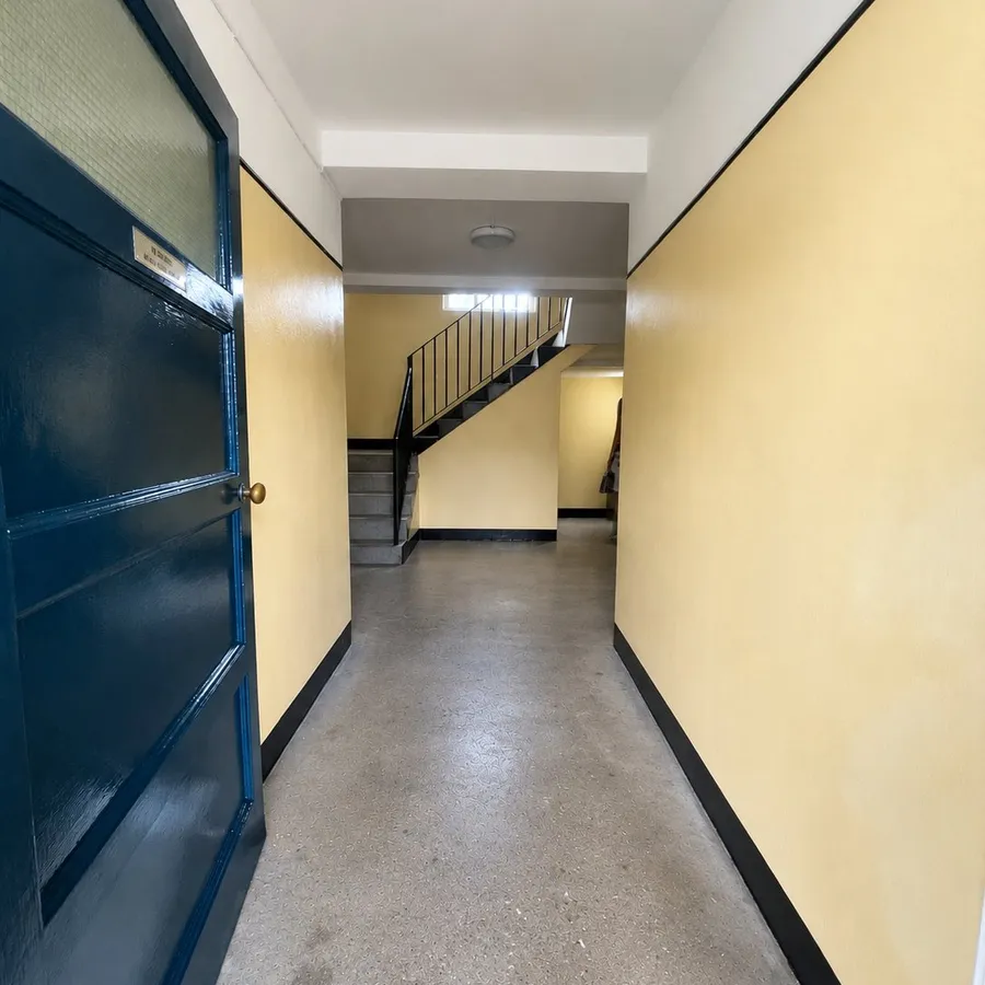 Repainted communal tenement corridor with navy door, Edinburgh